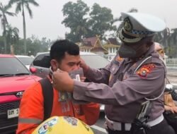 Polisi Bersama Masyarakat Ditlantas Polda Riau Bagikan Masker